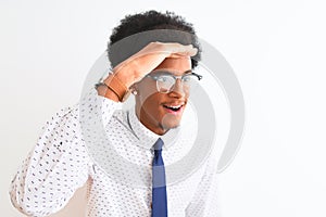 Young african american businessman wearing tie and glasses over isolated white background very happy and smiling looking far away