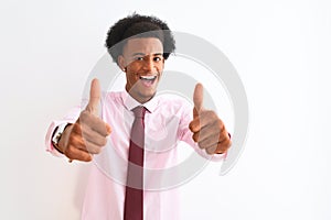 Young african american businessman wearing tie standing over isolated white background approving doing positive gesture with hand,