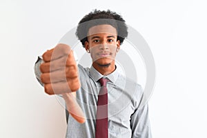 Young african american businessman wearing tie standing over isolated white background looking unhappy and angry showing rejection