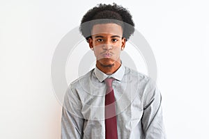 Young african american businessman wearing tie standing over isolated white background puffing cheeks with funny face