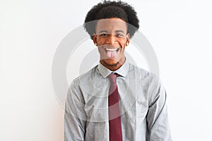 Young african american businessman wearing tie standing over isolated white background sticking tongue out happy with funny