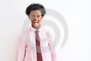 Young african american businessman wearing tie standing over isolated white background sticking tongue out happy with funny