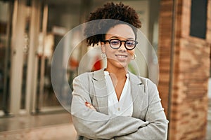 Young african american businesswoman with arms crossed standing at the city