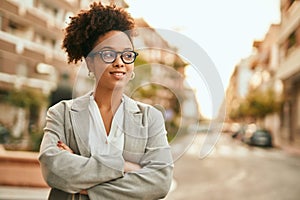 Young african american businesswoman with arms crossed standing at the city