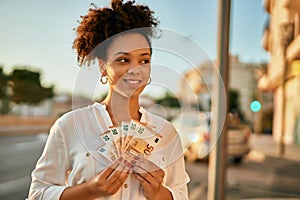 Young african american businesswoman holding 50 euro banknotes at the city