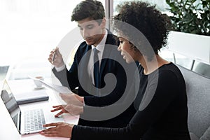 Young african american businesswoman working on computer, supervisor checking documents.