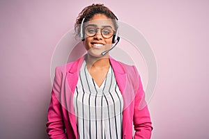 Young african american call center agent girl wearing glasses working using headset with a happy and cool smile on face