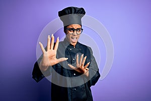 Young african american chef girl wearing cooker uniform and hat over purple background afraid and terrified with fear expression