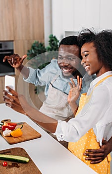 Young african american couple in aprons taking selfie