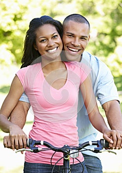 Young African American Couple Cycling In Park