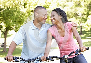 Young African American Couple Cycling In Park