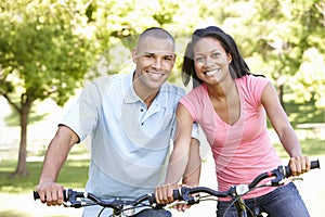 Young African American Couple Cycling In Park