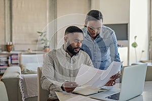 Young African American couple doing online banking at home