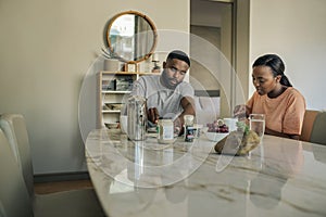 Young African American couple eating breakfast at their dining table