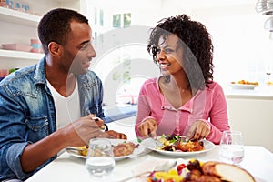 Young African American Couple Eating Meal At Home