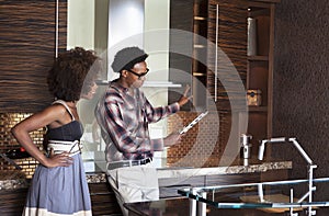 Young African American couple in new furnished Kitchen choosing materials