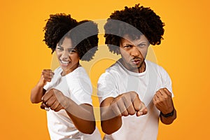 Young african american couple showing fists on background