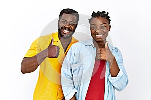 Young african american couple wearing casual clothes doing happy thumbs up gesture with hand