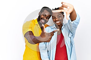 Young african american couple wearing casual clothes smiling making frame with hands and fingers with happy face