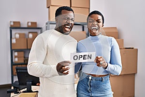 Young african american couple working at small business ecommerce angry and mad screaming frustrated and furious, shouting with