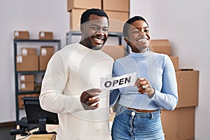 Young african american couple working at small business ecommerce winking looking at the camera with sexy expression, cheerful and