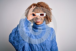 Young african american curly woman wearing 3d glasses over isolated white background doing ok gesture with hand smiling, eye