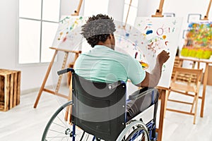 Young african american disabled artist man sitting on wheelchair drawing at art studio