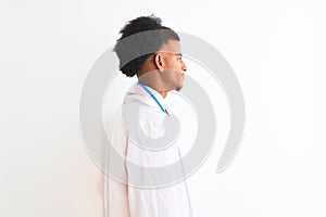 Young african american doctor man wearing sthetoscope over isolated white background looking to side, relax profile pose with
