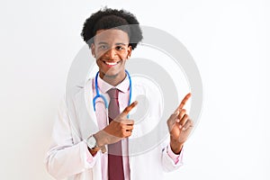 Young african american doctor man wearing sthetoscope over isolated white background smiling and looking at the camera pointing