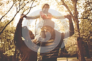 Young African American family in park together.