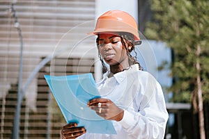 Young African American female engineer checking documents