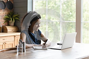 African American woman watch webinar on laptop at home