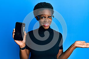 Young african american girl holding 5g technology smartphone celebrating achievement with happy smile and winner expression with