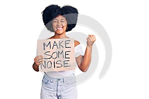 Young african american girl holding make some noise banner screaming proud, celebrating victory and success very excited with
