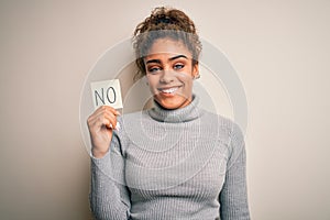 Young african american girl holding reminder paper with no word negative message with a happy face standing and smiling with a