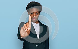 Young african american girl wearing business clothes pointing with finger up and angry expression, showing no gesture