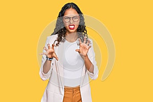 Young african american girl wearing business clothes smiling funny doing claw gesture as cat, aggressive and sexy expression