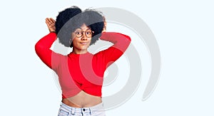 Young african american girl wearing casual clothes and glasses doing bunny ears gesture with hands palms looking cynical and
