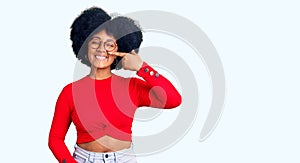 Young african american girl wearing casual clothes and glasses pointing with hand finger to face and nose, smiling cheerful