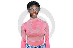 Young african american girl wearing casual clothes and glasses relaxed with serious expression on face