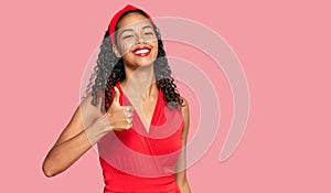Young african american girl wearing elegant and sexy look doing happy thumbs up gesture with hand