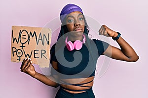 Young african american girl wearing sportswear holding woman power banner depressed and worry for distress, crying angry and