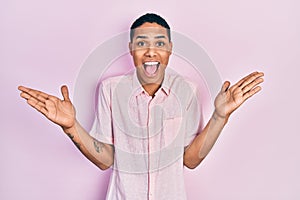 Young african american guy wearing casual clothes celebrating victory with happy smile and winner expression with raised hands