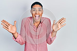 Young african american guy wearing casual clothes celebrating victory with happy smile and winner expression with raised hands