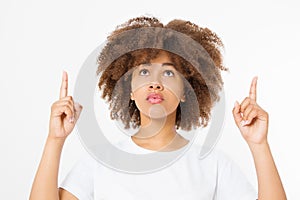 Young african american happy woman showing copyspace pointing on isolated white background. Afro hairstyle. Template, blank shirt.