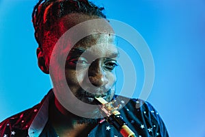 Young african-american jazz musician playing the saxophone