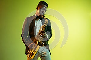 Young african-american jazz musician playing the saxophone photo