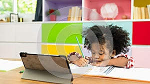Young African American kid girl studying using digital tablet, preschool child study at home school. homeschooling concept
