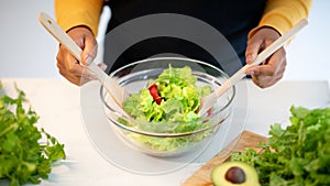 Young african american lady in apron prepare salad at table with organic vegetables in kitchen interior, top view