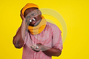 Young african american male wearing red checkered shirt with knitted scarf and hat feeling bad unwell with fever heat